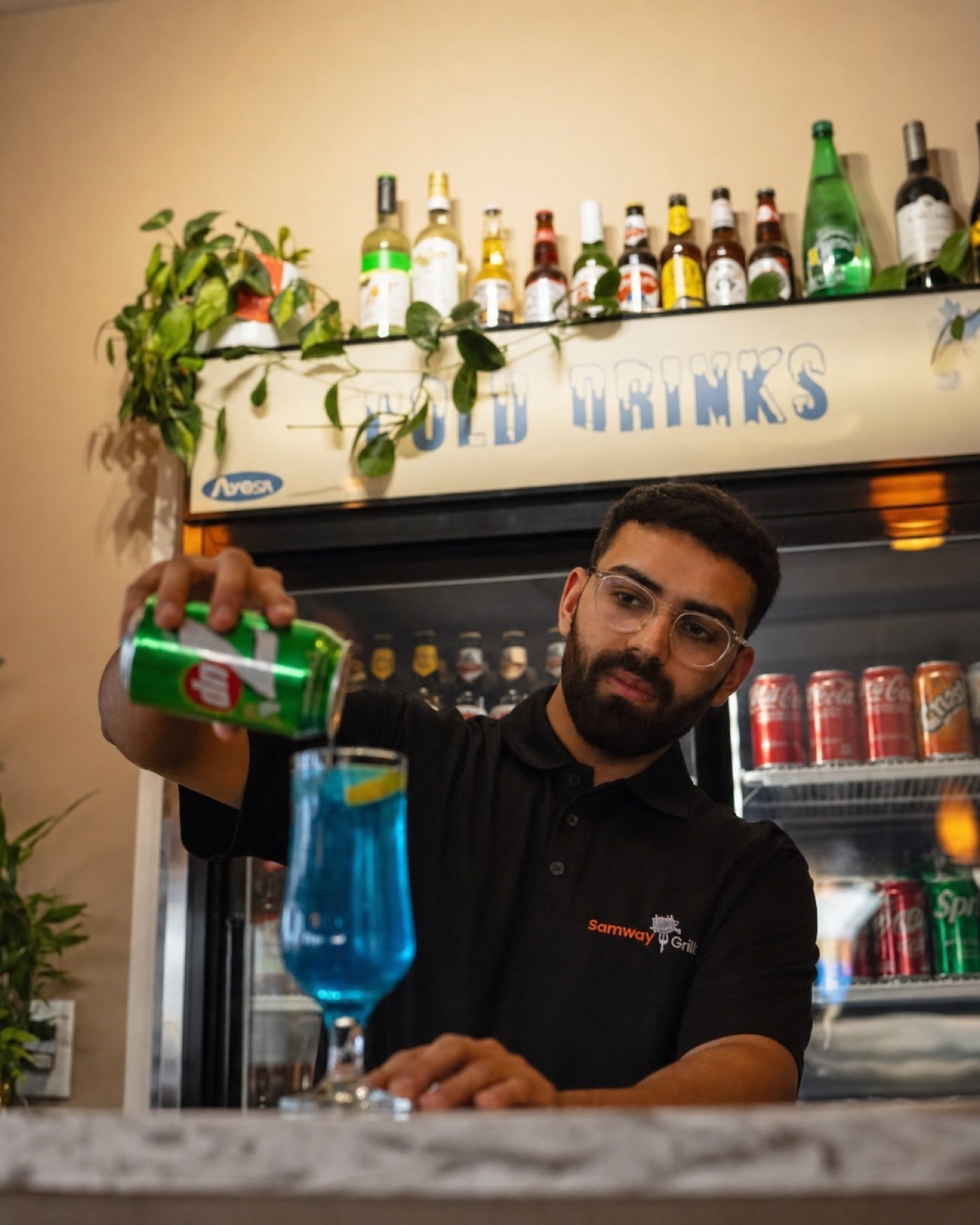 Samway Grill team member preparing a drink behind the service counter