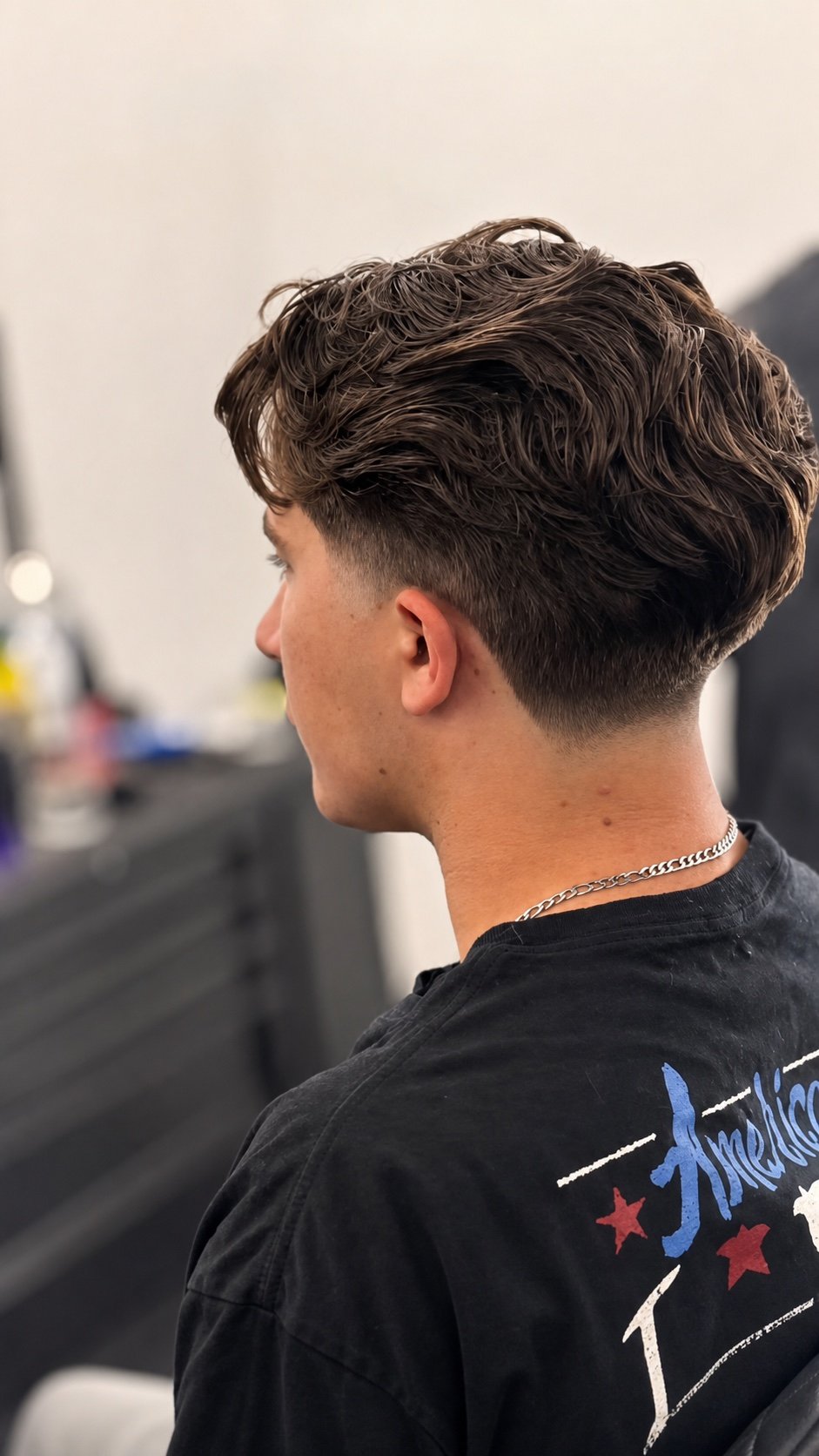 Textured haircut and clean side fade completed at TopTown Barbershop
